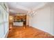 Open dining area view with hardwood floors, decorative chandelier, and kitchen at 4518 Courtyard Blvd # 4, Harrisburg, NC 28075