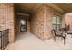 Inviting covered porch with brick columns, seating area, and stylish front door at 4518 Courtyard Blvd # 4, Harrisburg, NC 28075