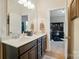 Bright bathroom with dual vanities and an open doorway leading to an office space at 463 Langston Place Dr, Fort Mill, SC 29708