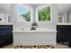 Relaxing bathroom featuring a soaking tub under sunny windows with dark vanities on either side at 463 Langston Place Dr, Fort Mill, SC 29708