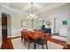 The dining room features a coffered ceiling, modern chandelier, and seamless entry to the kitchen at 463 Langston Place Dr, Fort Mill, SC 29708