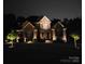 Stately home at night with manicured lawn and professional outdoor lighting at 463 Langston Place Dr, Fort Mill, SC 29708