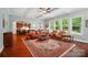 Bright living room with coffered ceilings, hardwood floors, large windows, and an open view to the kitchen at 463 Langston Place Dr, Fort Mill, SC 29708