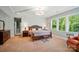 Spacious main bedroom with a plush bed, sitting area, and large windows at 463 Langston Place Dr, Fort Mill, SC 29708