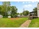 Picturesque backyard featuring green lawn, fire pit, wooden fence, and a covered deck at 510 Sw Viking Sw Pl, Concord, NC 28025