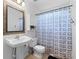 Clean bathroom featuring a pedestal sink, wood-trimmed mirror, toilet, and shower with blue curtain at 510 Sw Viking Sw Pl, Concord, NC 28025