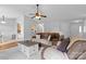 Open-concept living room featuring hardwood floors, plush sofas, and a view into the kitchen at 510 Sw Viking Sw Pl, Concord, NC 28025