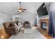Comfortable living room with a ceiling fan, brick fireplace, hardwood flooring, and plush furnishings at 510 Sw Viking Sw Pl, Concord, NC 28025