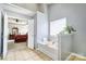Bright bathroom with a soaking tub and view into the main bedroom at 511 Rough Hewn Ln, Rock Hill, SC 29730