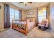 Cozy bedroom featuring a wrought iron bed frame, neutral decor, and lots of natural light from the two large windows at 511 Rough Hewn Ln, Rock Hill, SC 29730