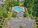 Aerial view of a community pool with a clubhouse, parking, lounge chairs, and lush landscaping at 511 Rough Hewn Ln, Rock Hill, SC 29730