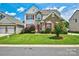Charming home featuring brick accents, red shutters, a well-maintained lawn, and mature landscaping at 511 Rough Hewn Ln, Rock Hill, SC 29730
