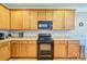 Kitchen featuring wooden cabinets, black appliances, and tiled backsplash at 511 Rough Hewn Ln, Rock Hill, SC 29730