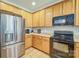 Bright kitchen with stainless steel refrigerator and wooden cabinets at 511 Rough Hewn Ln, Rock Hill, SC 29730
