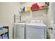 Bright laundry room featuring a modern washer and dryer, shelving for storage, and white walls at 511 Rough Hewn Ln, Rock Hill, SC 29730