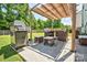 Outdoor patio with a pergola, grill, and comfortable seating area for outdoor dining and entertaining at 511 Rough Hewn Ln, Rock Hill, SC 29730