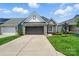 Charming home with a stone and siding exterior, well-manicured lawn, and a two-car garage at 6277 Raven Rock Dr, Denver, NC 28037