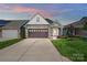 Charming home with a stone and siding exterior, well-manicured lawn, and a two-car garage at 6277 Raven Rock Dr, Denver, NC 28037