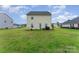 Back exterior view of the home highlighting the expansive green backyard and adjacent properties at 635 Scarlet Leaf Ln, Oakboro, NC 28129