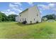 Rear exterior view of a home with a lush green backyard, patio area, and surrounding trees at 635 Scarlet Leaf Ln, Oakboro, NC 28129