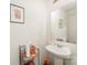 Modern half bathroom featuring a pedestal sink, decorative mirror, and neutral color palette at 635 Scarlet Leaf Ln, Oakboro, NC 28129