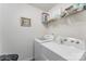 Bright laundry room featuring a white washer and dryer set with shelving above for storage at 635 Scarlet Leaf Ln, Oakboro, NC 28129