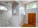 Bright bathroom featuring neutral tile shower, hardwood floors, and wood door storage at 660 Ideal Way, Charlotte, NC 28203