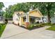 Spacious yellow home with a welcoming front porch, long drive way, and lush landscaped grounds at 660 Ideal Way, Charlotte, NC 28203