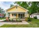 Inviting yellow home with a classic front porch, rocking chairs, and meticulously landscaped front yard at 660 Ideal Way, Charlotte, NC 28203