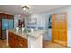 Kitchen island with granite countertop, cabinets and barstool seating overlooking shelving and decor at 660 Ideal Way, Charlotte, NC 28203