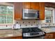 Close-up of the gas range and stainless microwave with granite countertops and tile backsplash at 660 Ideal Way, Charlotte, NC 28203