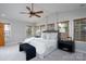 This main bedroom features a ceiling fan, bench, and multiple windows providing natural light at 660 Ideal Way, Charlotte, NC 28203