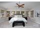 This main bedroom features a ceiling fan, bench, and multiple windows providing natural light at 660 Ideal Way, Charlotte, NC 28203