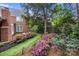 Serene backyard garden with lush landscaping and a charming brick walkway at 6916 Cameron Glen Dr, Charlotte, NC 28210