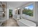 A spacious bathroom featuring a soaking tub, large window, double vanity, and modern fixtures at 6916 Cameron Glen Dr, Charlotte, NC 28210