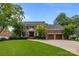 Beautiful brick home with a manicured lawn, mature trees, and a two-car garage at 6916 Cameron Glen Dr, Charlotte, NC 28210