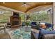 Enjoy the screened-in patio with wood ceiling, tiled floor, brick fireplace, and comfortable seating overlooking the yard at 6916 Cameron Glen Dr, Charlotte, NC 28210
