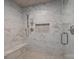 A walk-in shower featuring modern tiles, a built-in bench, and a niche for storage at 6916 Cameron Glen Dr, Charlotte, NC 28210