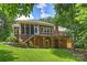 Back exterior view showcasing the brick facade, decks, and landscaped yard at 7117 Cobblecreek Dr, Weddington, NC 28104