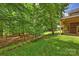 Lush backyard with a grassy lawn and wooded area seen from the deck at 7117 Cobblecreek Dr, Weddington, NC 28104