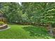 Expansive backyard featuring a manicured lawn and a wooded backdrop at 7117 Cobblecreek Dr, Weddington, NC 28104