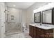 Beautiful bathroom showcasing a glass shower, a dual-sink vanity with marble countertops, and neutral tiling at 7117 Cobblecreek Dr, Weddington, NC 28104