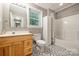 Bathroom with updated wood vanity, patterned floors, and a shower-tub combination at 7117 Cobblecreek Dr, Weddington, NC 28104