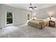 Bright bedroom featuring plush carpeting, a ceiling fan, and serene outdoor views from a large picture window at 7117 Cobblecreek Dr, Weddington, NC 28104