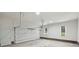 Clean, bright garage with white walls, large overhead door, and windows with brick trim at 7117 Cobblecreek Dr, Weddington, NC 28104