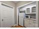 Pantry area featuring white cabinets, countertop space and refrigerator convenient for storage at 7117 Cobblecreek Dr, Weddington, NC 28104