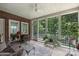 Cozy screened porch featuring comfortable furniture and views of the green, wooded landscape at 7117 Cobblecreek Dr, Weddington, NC 28104