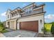 Modern two-story home with a stylish white and gray exterior and a brown wood garage door at 716 Flare Dr, Tega Cay, SC 29708