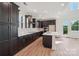 Kitchen with stainless appliances, an island, dark cabinets, and plenty of natural light at 716 Flare Dr, Tega Cay, SC 29708