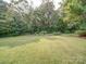 Sprawling backyard with a garden, mature trees, and well-maintained lawn offers space and privacy at 8101 Cane Pointe Ln, Waxhaw, NC 28173